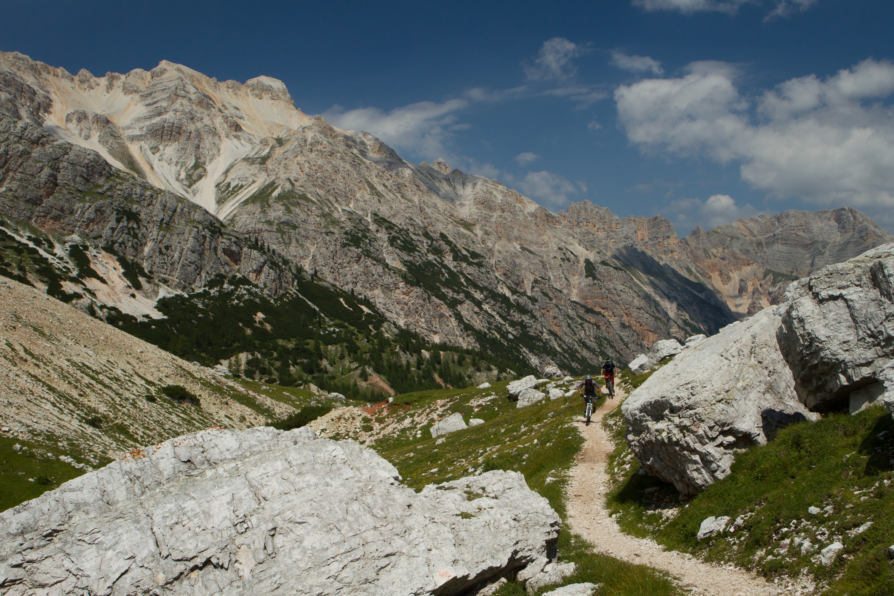 Two riders heading deeper into a Dolomites-style alpine valley